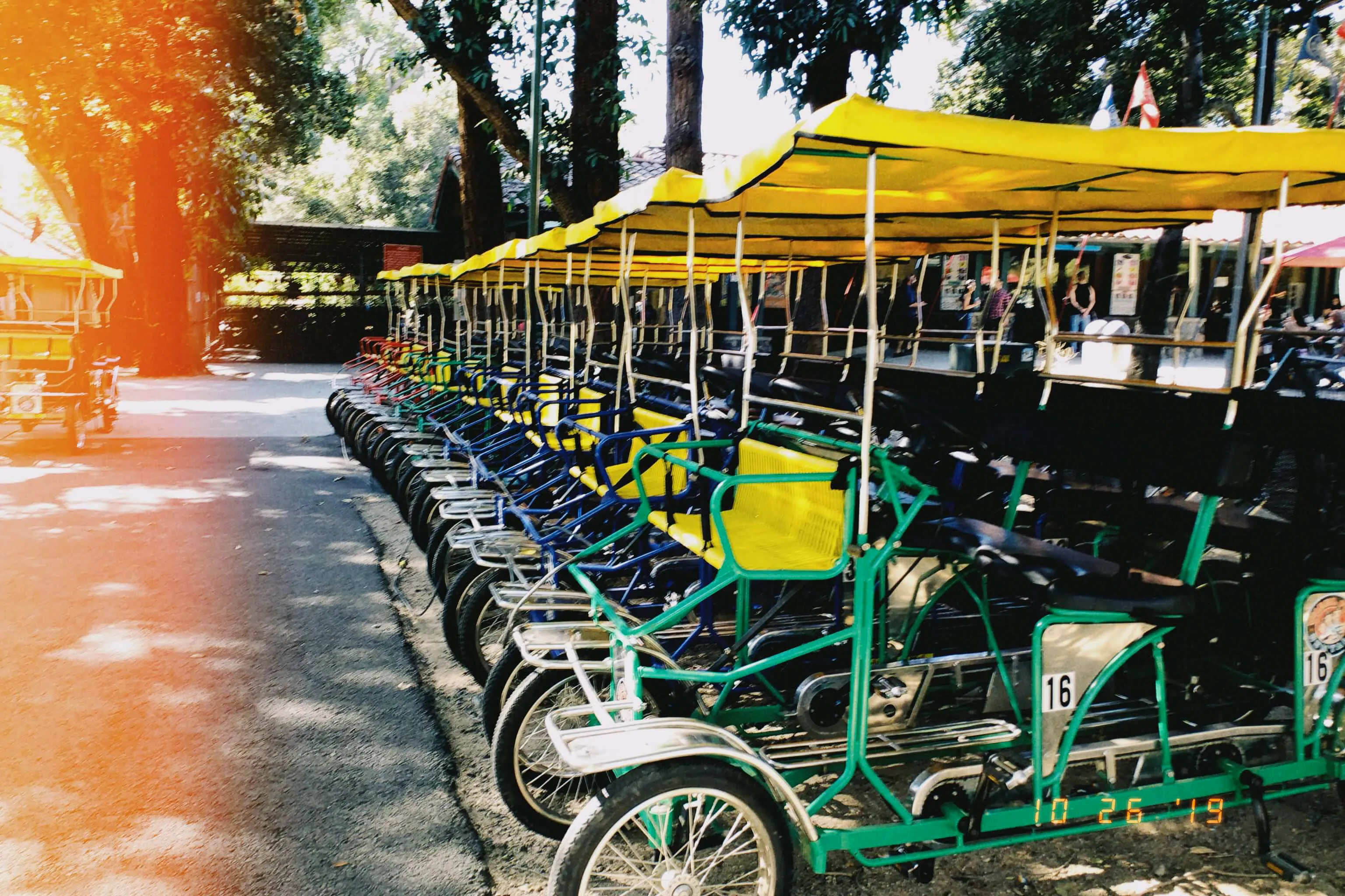 A row of colorful carts in a paved area in a park.