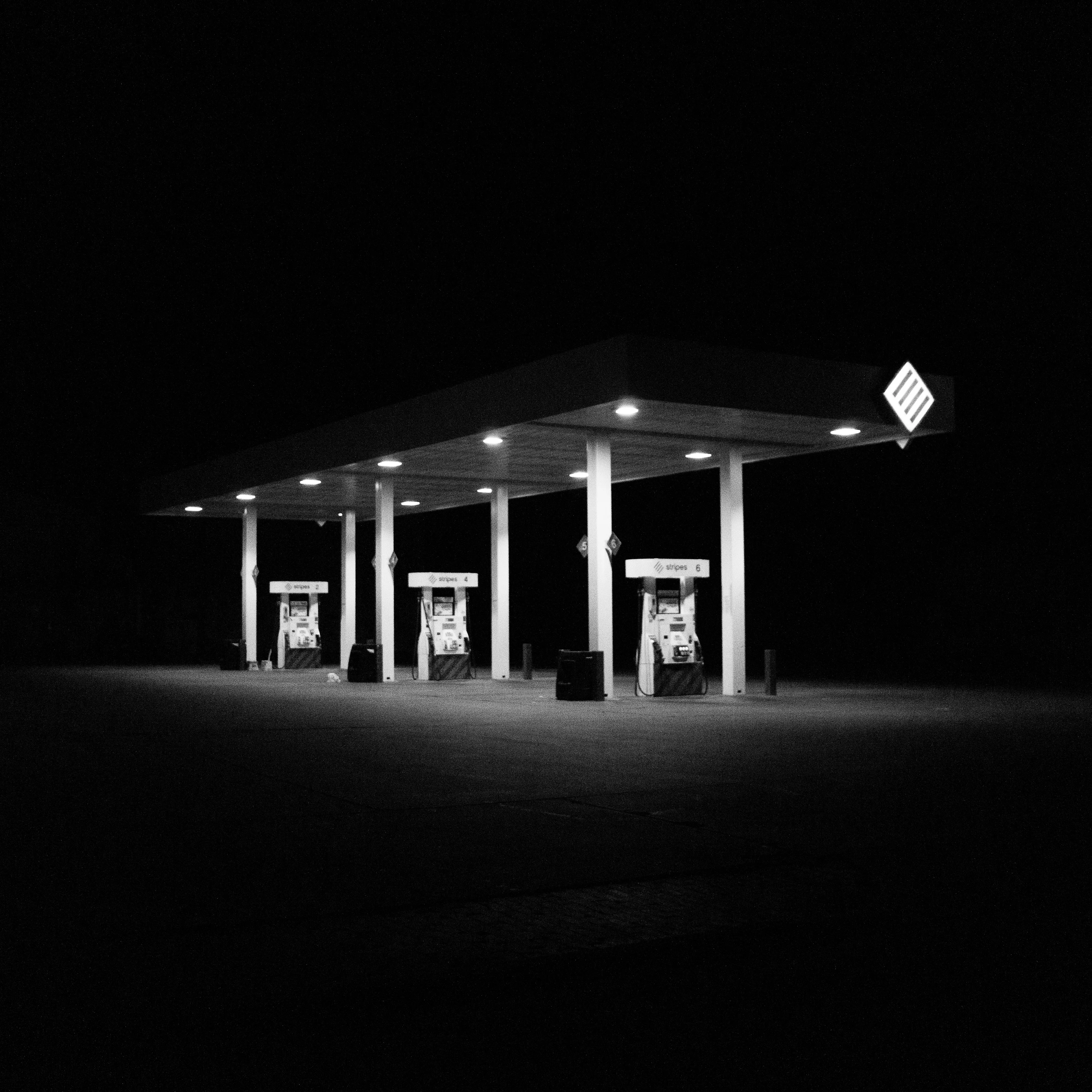 A gas station at night, surrounded by total darkness.