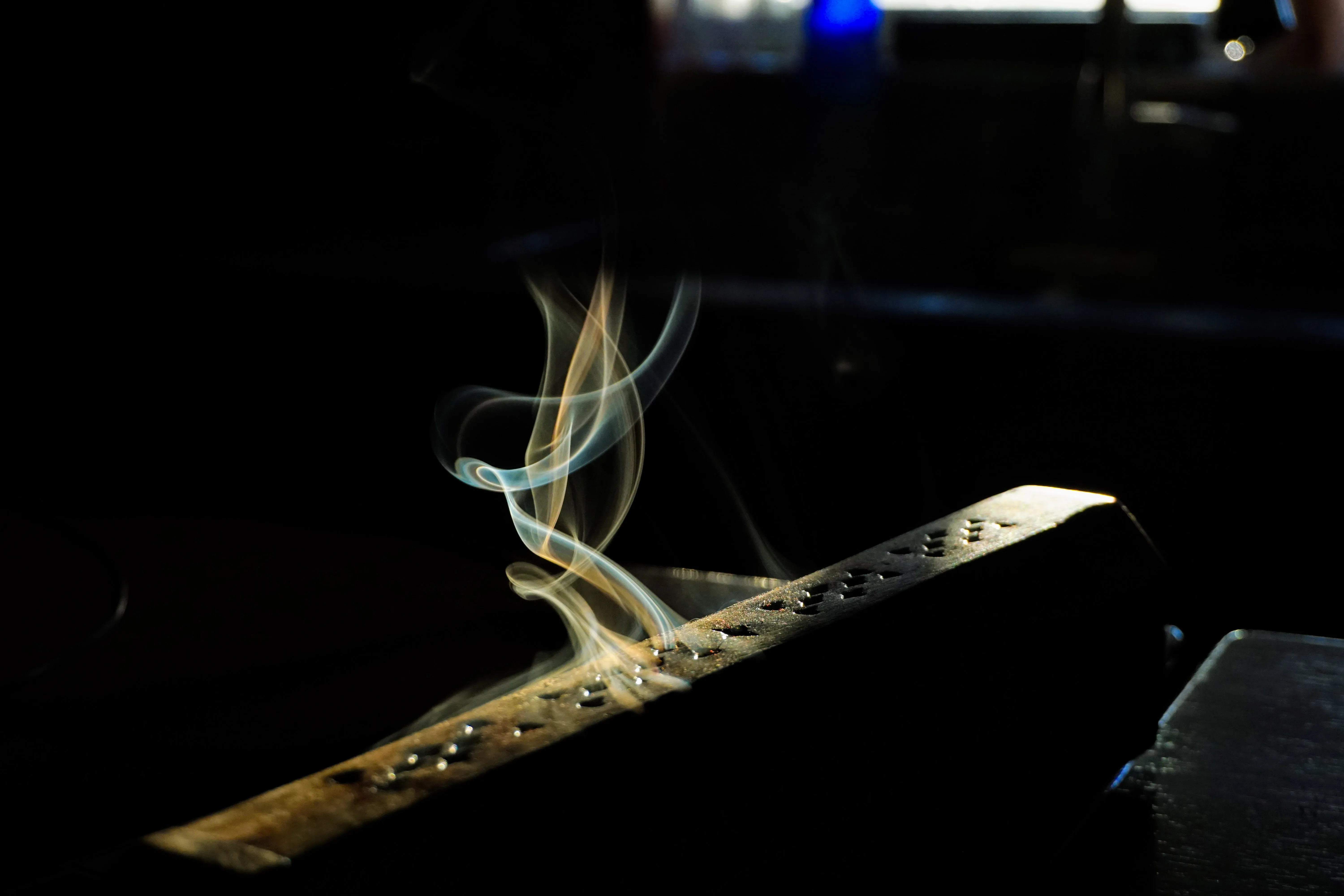 A incense burner with smoke trailing up and out.