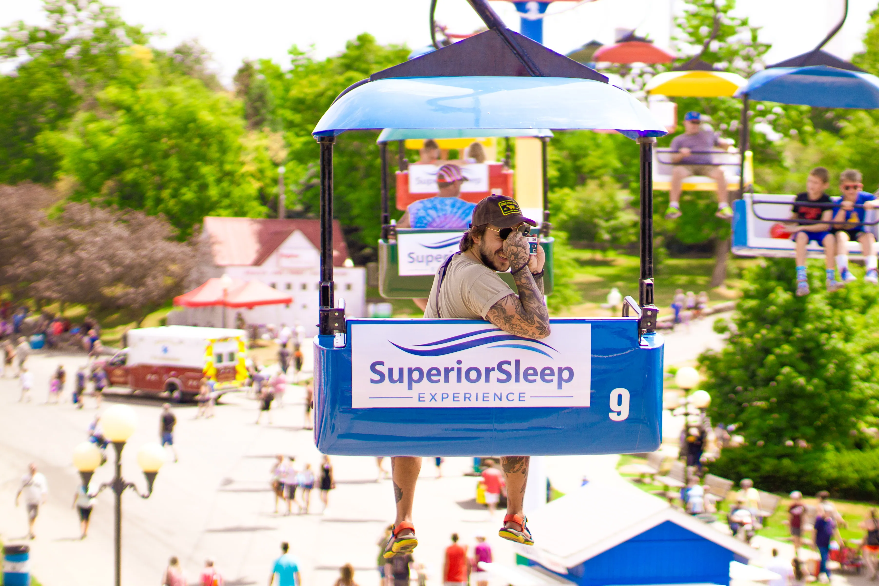 A man on a skyglider taking a photo with a polaroid camera.