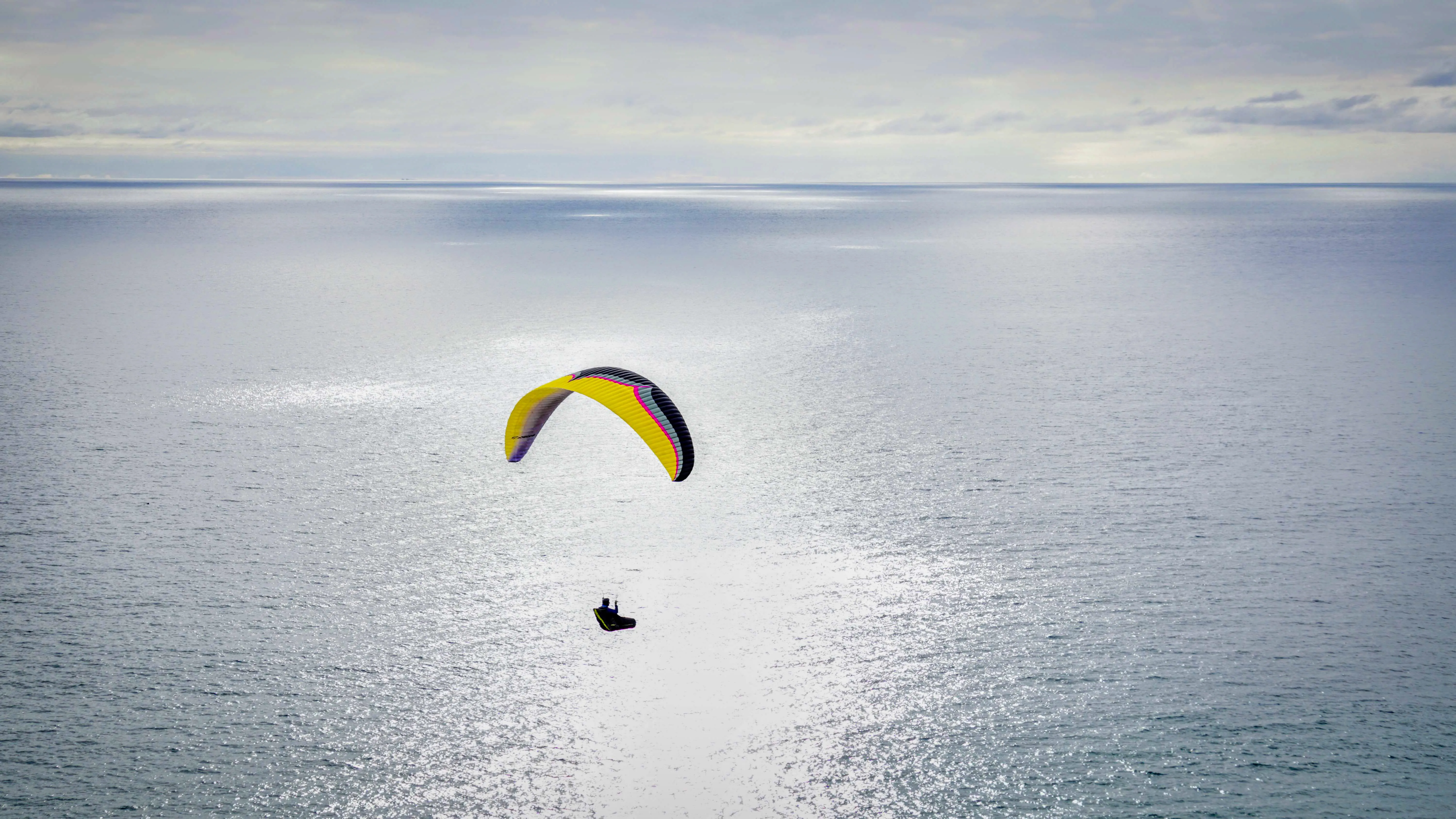 A parasailer flying out over the ocean.