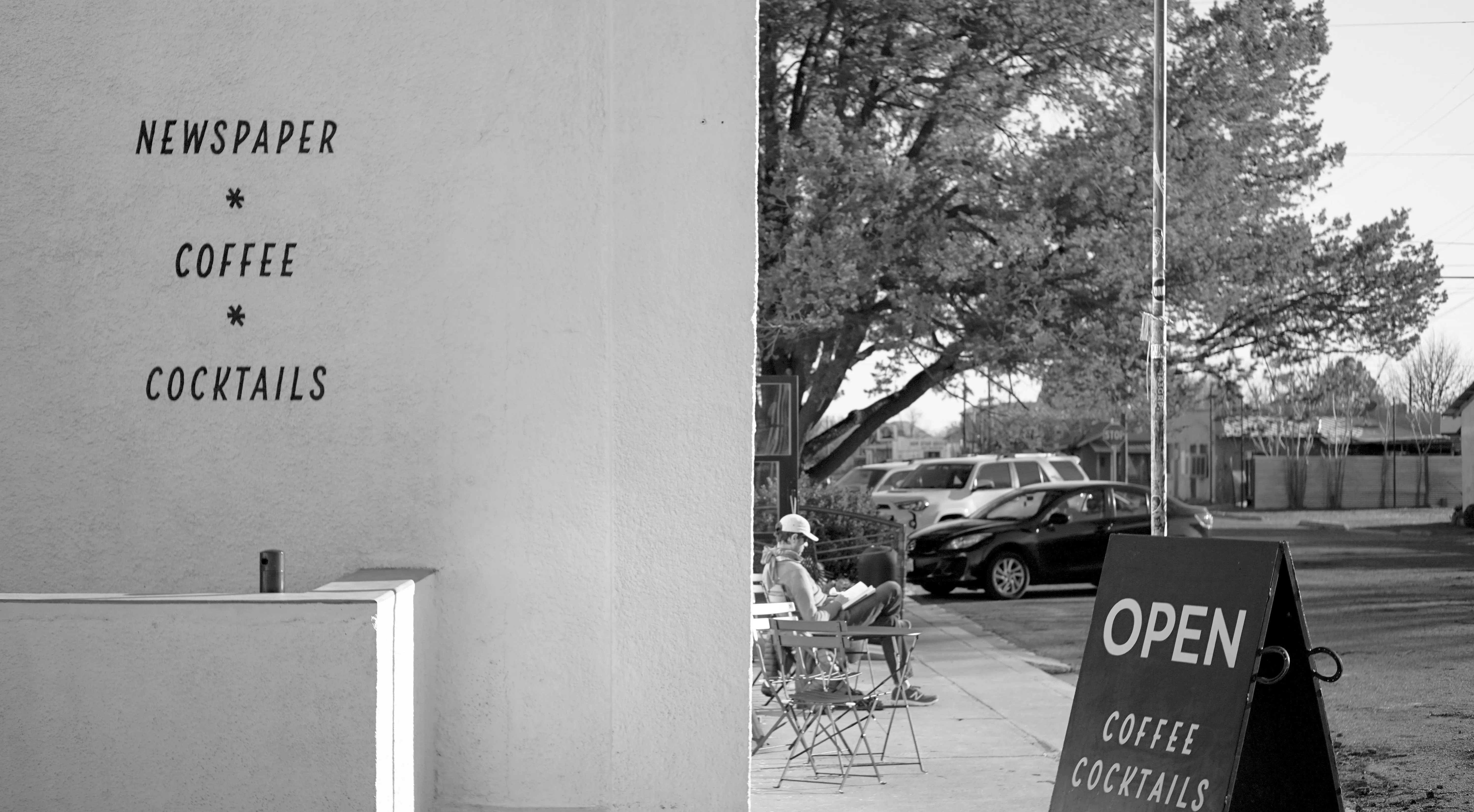 A man reading outside a cafe.