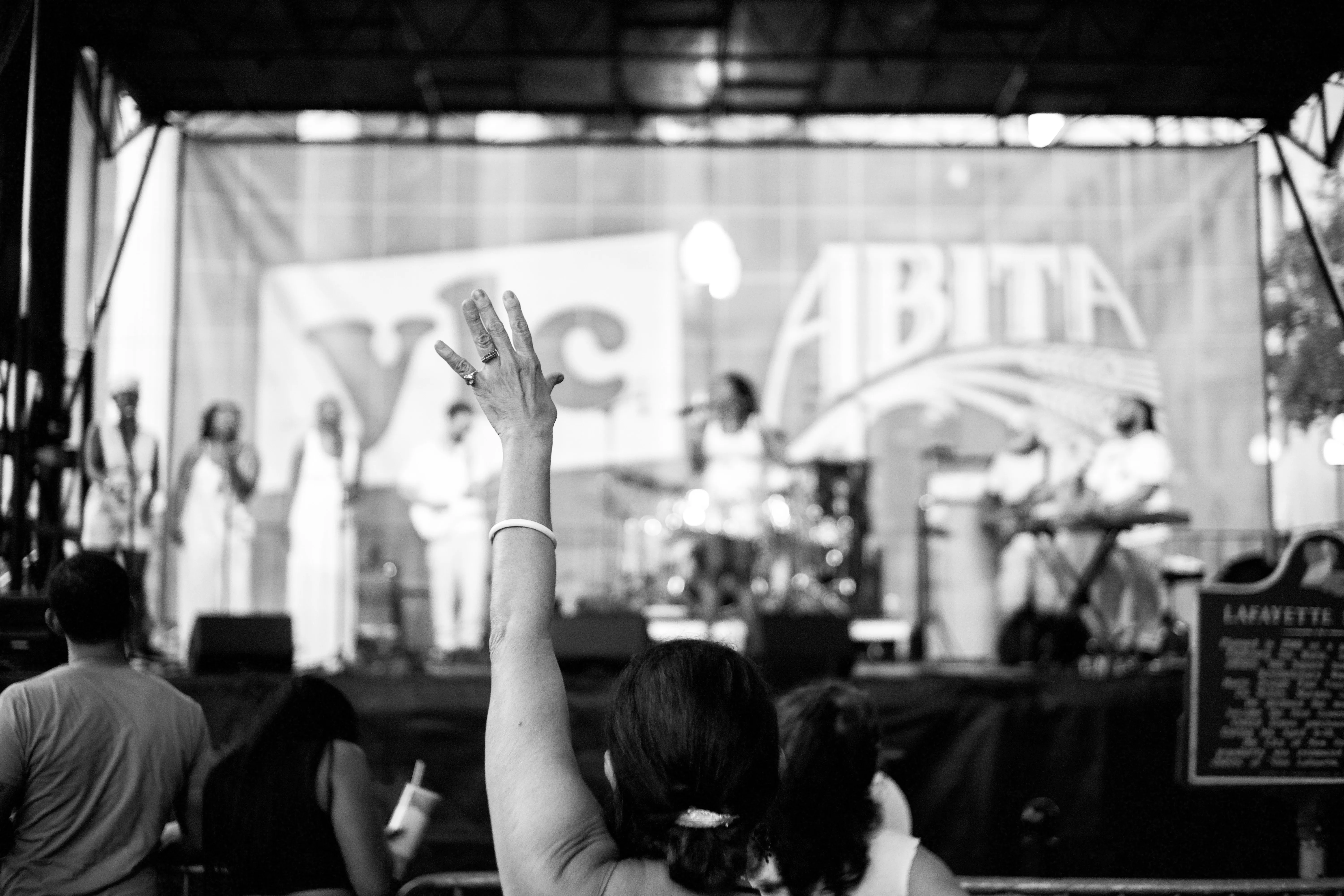 A woman at a soul concert raising her hand to the music.